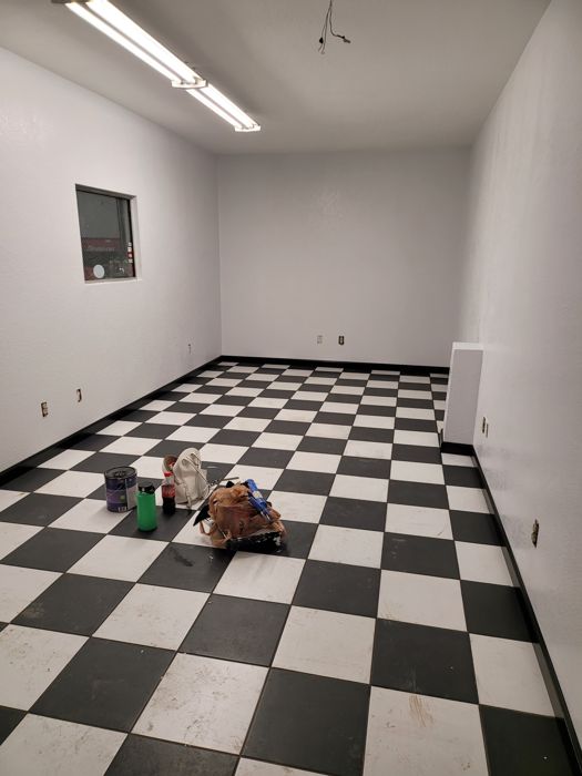 Checkerboard tile floor with black baseboard trim