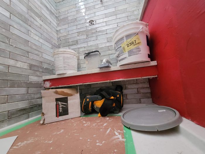 Shower with gray subway tile and tiled bench in progress